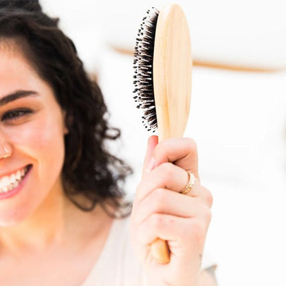 Femme souriante utilise Brosse poil de sanglier 